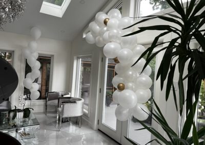 white with gold balloon garland and a group of 11 white balloons