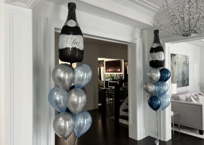 Champagne bottle balloon in a pillar of 9 blue and silver balloons